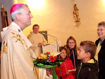 Jannik überreicht dem Erzbischof Blumen.  Fotos: Johanna Blum