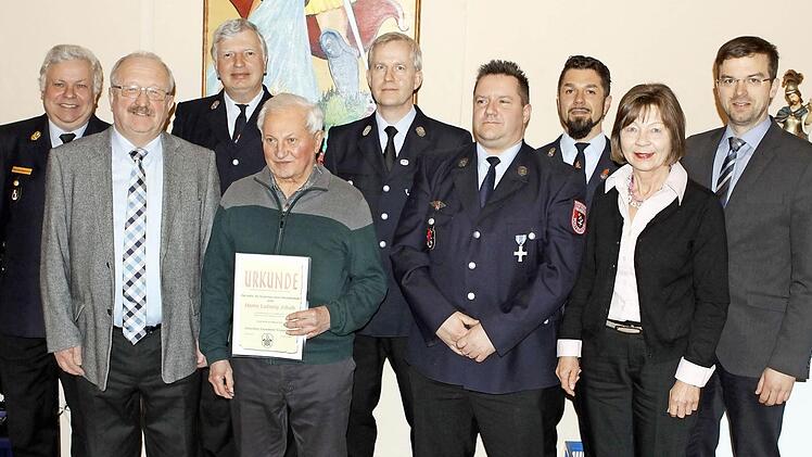 Ludwig Jakob und der aktive Feuerwehrmann Michael Brand (vorne in der Mitte) wurden bei der Hauptversammlung der Vogtendorfer Wehr ausgezeichnet.  Foto: Michael Wunder