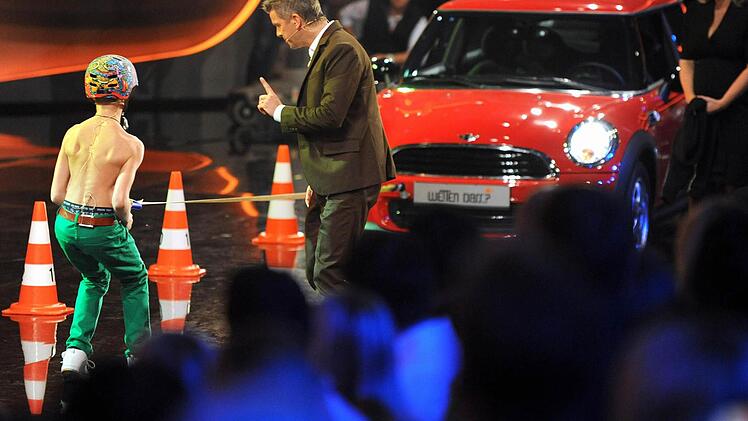 Moderator Markus Lanz begleitet am 03.11.2012 in der ZDF-Livesendung "Wetten dass..?" aus Bremen, den 13-j&auml;hrigen Tim Schmidt-Sibeth (l) bei dem Ziehen des roten Autos. Foto: Ingo Wagner/dpa