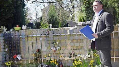 Michael Beutel zeigt den Ort der Baumbestattung auf dem Friedhof. An dem Stein lassen sich Gedenktäfelchen anbringen. Foto: Daniela Pondelicek
