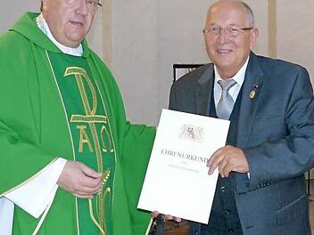 Aus der Hand von Pfarrer Günther Höfer erhielt Jürgen Hollmann die Urkunde der bayerischen Arbeitsministerin Emilia Müller.  Foto: Bärbel Meister