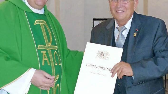 Aus der Hand von Pfarrer Günther Höfer erhielt Jürgen Hollmann die Urkunde der bayerischen Arbeitsministerin Emilia Müller.  Foto: Bärbel Meister