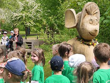 Leiterin Irmgard Redel mit Kindern vor der Walli-Maus-Skulptur im Gelände des Kindergartens. Die Skulptur ist Teil des Weges und eine Arbeit von Klemens Heumann.  Foto: Gökhan Effenhauser
