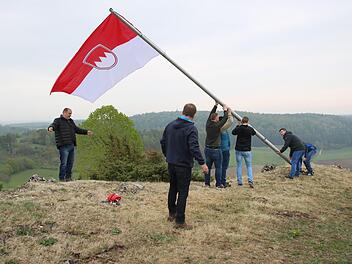 Mit vereinten Kräften wird die am Fahnenmast angebrachte neue Frankenflagge in die Senkrechte gebracht. Foto: Matthias Einwag