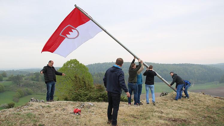 Mit vereinten Kräften wird die am Fahnenmast angebrachte neue Frankenflagge in die Senkrechte gebracht. Foto: Matthias Einwag