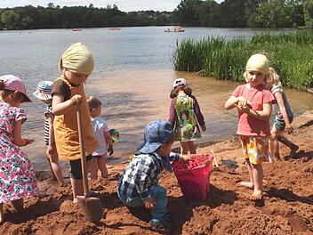 Viele Kleinkinder tummelten sich auf der großen Sandburg direkt am See und buddelten eifrig im Sand.