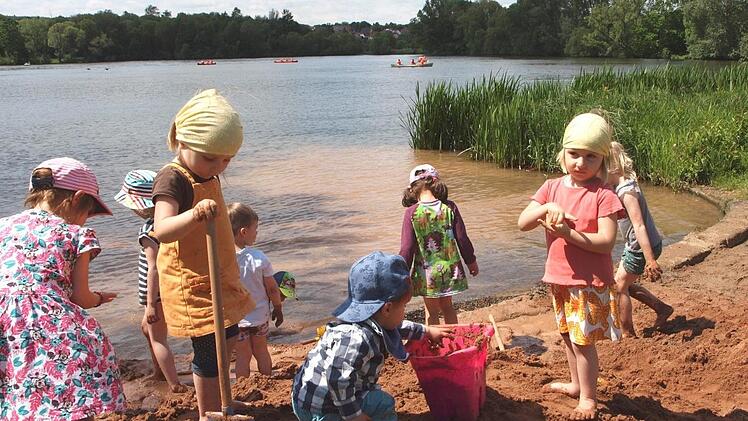 Viele Kleinkinder tummelten sich auf der großen Sandburg direkt am See und buddelten eifrig im Sand.