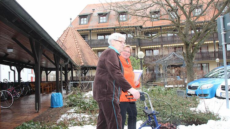 Pflegedienstleiterin Christine Bernhagen (rechts) begleitet eine Seniorin über den Hof des Katharinenspitals. Dort, wo sich jetzt der überdachte Gang befindet, soll ein Neubau entstehen. Das Haupthaus im Hintergrund wird umgebaut.  Fotos: Andreas Oswald