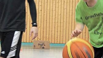 Johannes dribbelt möglichst schnell durch den Slalom-Parcours und über die Bank, wobei ihm Jugendtrainer Felix (links) helfend zur Seite steht. Foto: Ralf Kestel