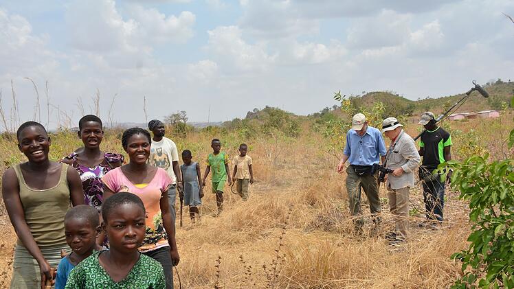 Regisseur Volker Schl&ouml;ndorff (zweiter von rechts) und der Agrarwissenschaftler Tony Rinaudo (dritter von rechts) besuchen im Film zusammen mit der Bev&ouml;lkerung Gebiete, die wieder aufgeforstet werden sollen.