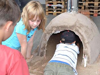 Der Sand muss raus, bevor zum ersten Mal Feuer im selbst gebauten Lehmofen gemacht werden kann. Fotos: Sonja Adam, Uschi Prawitz und Markus Roider