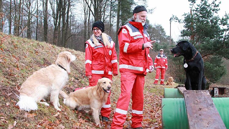 "Ayk", schwarzer Labrador, sechs Jahre alt, Rettungshund: Mit seinem Herrchen, Thomas Schuhmann (Mitte), ist er im Einsatz, wenn Menschen bei der Polizei als vermisst gemeldet werden und die Beamten ihre Hilfe brauchen. Anja Schneider leitet die Rettungshundestaffel des Kreisverbandes des Roten Kreuzes seit diesem Monat. Erich Mock (im Hintergrund) ist ihr Stellvertreter. Fotos: Carmen Schmitt