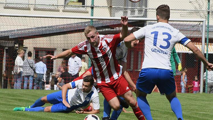 Ein kampfbetontes Spiel mit dem Punktgewinn für beide Mannschaften: Fuchsstadts Florian Seidl (Mitte) wird in dieser Szene von Unterpleichfelds Andreas Zehner (hinten) und Dominik Oßwald (rechts) zu Fall gebracht. Foto: Hopf