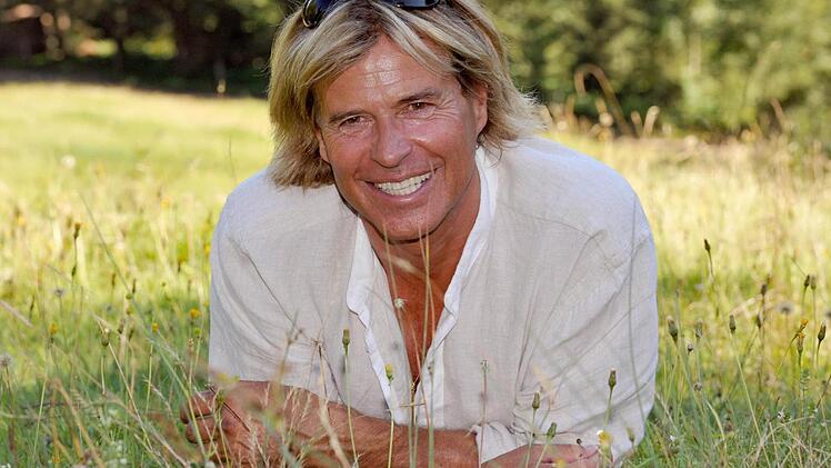 Hansi Hinterseer auf einer Almwiese: Ob da die Milch der glücklichen Alpenkühe sauer wird? Foto: Ursula Düren/dpa