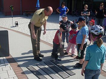 "Wir bauen einen Zebrastreifen": Verkehrserzieher und Polizist Martin Kaiser mit den Jüngsten der Franz-von-Prümmer-Schule beim Verkehrsprojekt. Foto: Klaus Scheuring