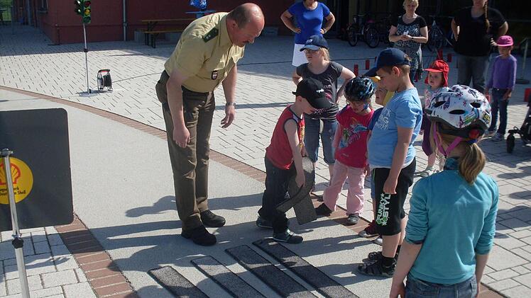 "Wir bauen einen Zebrastreifen": Verkehrserzieher und Polizist Martin Kaiser mit den Jüngsten der Franz-von-Prümmer-Schule beim Verkehrsprojekt. Foto: Klaus Scheuring