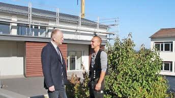 Philipp Reiter (rechts) erläutert Bürgermeister Helmut Blank den Ablauf der Dacharbeiten an der Turnhalle. Aber auch das Dach der Grundschule (rechts im Hintergrund) ist sanierungsbedürftig.Foto: Heike Beudert
