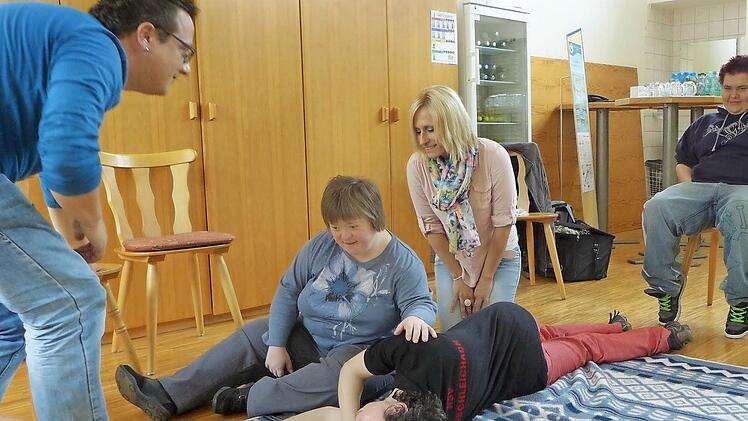 Um bei einer Verletzung schnell und richtig handeln zu können, werden die wichtigsten Handgriffe und Verhaltensweisen geübt. Im Bild (v. li.): Dozent Frank Zimmermann, Sarah Rinkowitz, Klaudia Karg (liegend), OGA-Ansprechpartnerin Angelika Seifert, Denise Benischek und Esther Neugebauer.