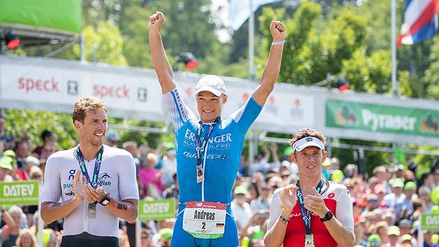 Der Michelauer Andreas Dreitz (Mitte) jubelt bei der Challenge Roth &uuml;ber den ersten Platz neben dem zweitplazierten Jesper Svensson aus Schweden (links) und dem Dritten, Cameron Wurf aus Australien. Foto: dpa/Daniel Karmann
