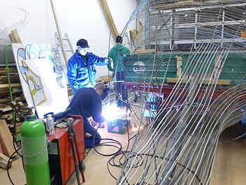 Das schweißt zusammen: Helfer bauen den Motivwagen des Jugendraums. Fotos: privat