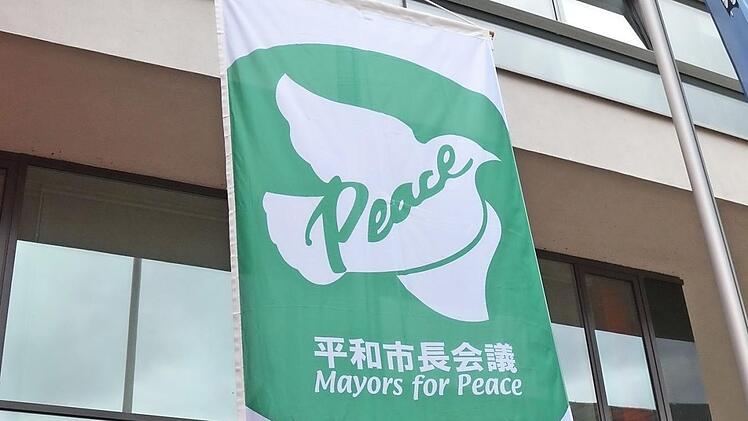 Bürgermeister German Hacker und Werner Mesnaric hissten am Jahrestag der "Mayors for Peace" am Herzogenauracher Interimsrathaus die Flagge.  Foto: Bernhard Panzer