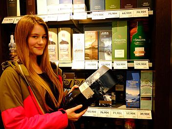 So sehen glückliche Kunden aus: Saskia freut sich über die große Whisky-Auswahl im Duty-free-Shop am Nürnberger Flughafen, bevor sie zu einem Termin fliegt. Foto: Nikolas Pelke