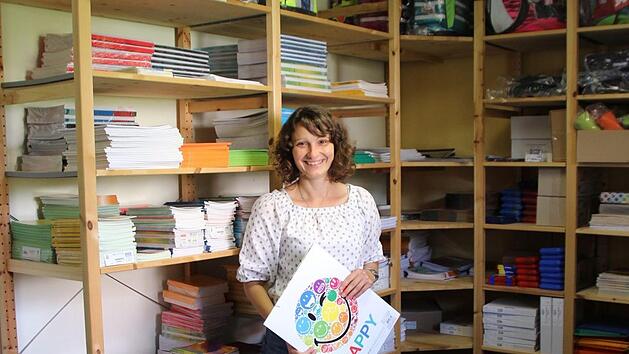 Sozialp&auml;dagogin Tanja V&ouml;lker vor den voll gef&uuml;llten Gr&uuml;nstift-Regalen. Hochwertiges Schulmaterial und Schulranzen werden ausgegeben. Fotos: Christiane Lehmann