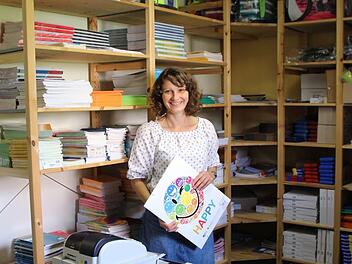 Sozialpädagogin Tanja Völker vor den voll gefüllten Grünstift-Regalen. Hochwertiges Schulmaterial und Schulranzen werden ausgegeben. Fotos: Christiane Lehmann