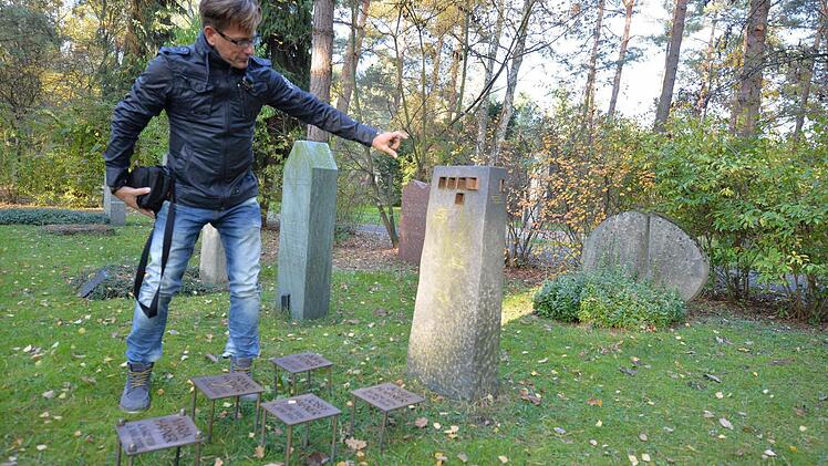 Michael Gärtner erklärt das 2005 von Andreas Geisselhardt aus Leonberg geschaffene Grabmal. Bei diesem puristisch gestalteten Grabzeichen beziehen sich die fünf quadratischen Durchbrüche auf fünf Namenstafeln aus Bronze.Dabei fällt an markanten Terminen, z. B. die Geburtsstunde, bei schönem Wetter Licht auf die jeweilige Namenstafel. Foto: Ronald Rinklef