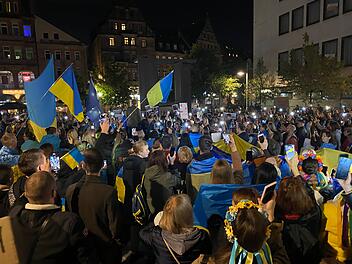 Ein Zeichen der Solidarität: Demonstrant*innen schaffen ein Meer aus Lichtern und Flaggen für die Menschen in der Ukraine.