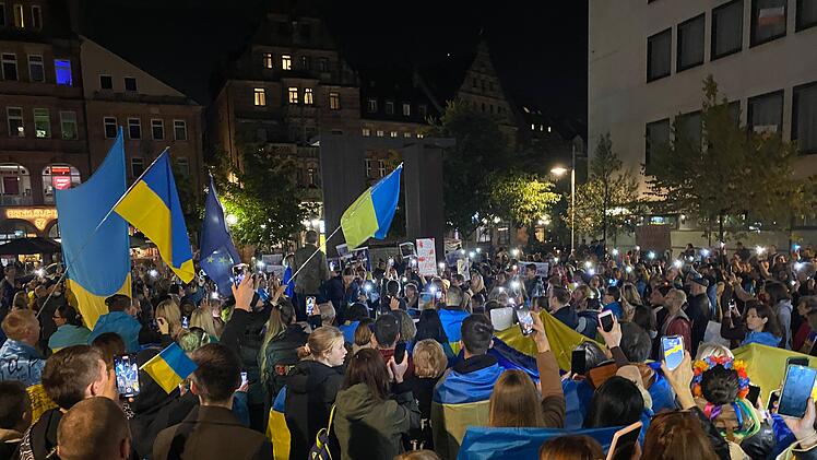 Ein Zeichen der Solidarität: Demonstrant*innen schaffen ein Meer aus Lichtern und Flaggen für die Menschen in der Ukraine.