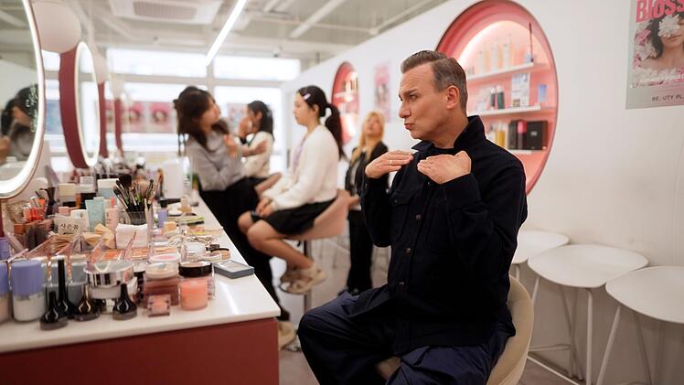 Fertig geschminkt posiert Tim Raue vor dem Spiegel - sein Fazit f&auml;llt allerdings wenig begeistert aus.