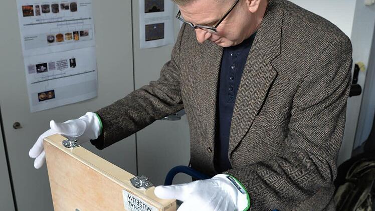 Roland Schewe öffnet die Kassette, in der die Henlein-Uhr verwahrt wird. Foto: Ronald Rinklef