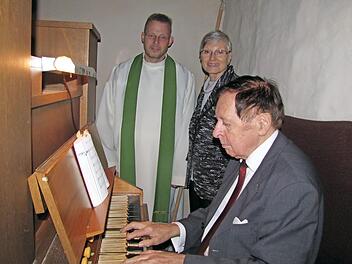 Walter Dorn spielt die Orgel der alt-katholischen St.-Nikolaus-Kapelle am Rosengarten, Pfarrer Hans-Jürgen Pöschl und Marie-Luise Plack, ehemals Vorsitzende des Kirchenvorstandes schauen ihm zu.  Foto: M. Koch