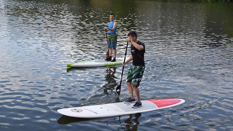 Locker sieht anders aus: Reporter Christian Pack hat anfangs sichtlich Mühe, auf dem SUP-Board stehen zu bleiben. SUP-Instruktor Gerhard Loch schaut hingegen ganz entspannt zu.  Fotos: Ronald Rinkleff