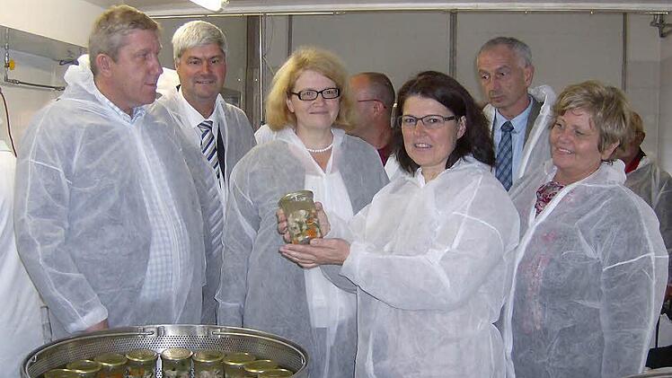 Die Politiker und Fachleute werden im weißen Schutzanzug zur Nudelproduktion geführt, wo die Hähne zu Frikassee im Glas verarbeitet werden.