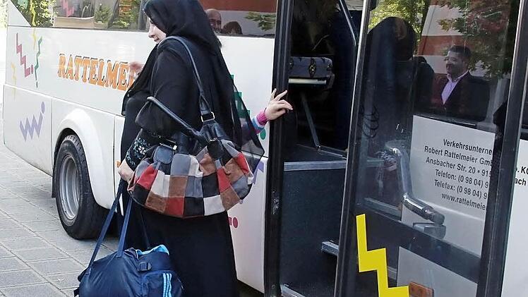 Mutter Fatima steigt aus dem Bus und ist froh, in Nürnberg angekommen zu sein. Nach über einem Jahr auf der Flucht findet sie mit ihrer Familie hier zumindest vorübergehend wieder ein Zuhause. Fotos: Matthias Hoch