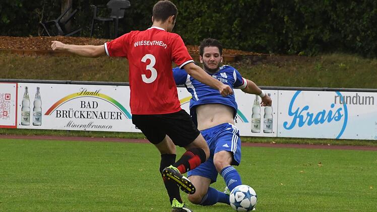 Einsatz und Geduld werden belohnt: Münnerstadts Spielführer Simon Snaschel (blaues Trikot) schoss seine Farben zum Lastminute-Sieg gegen den TSV/DJK Wiesentheid. Foto: Hopf