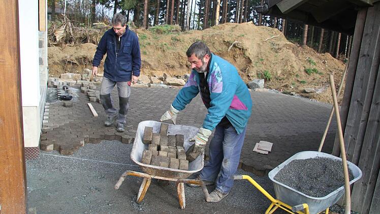 Wilfried Vogel und Josef Werner pflastern noch den Vorplatz der neuen Garage. Sobald die beiden Handwerker fertig sind, kann der neue Pistenbulli kommen - und bei Schneefall seine Dienste leisten. Foto: Sonja Adam