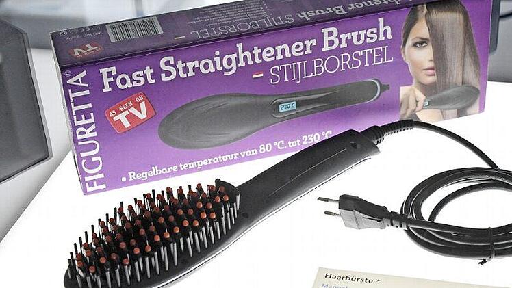 Eine Haar-Glättbürste in einer Ausstellung von beschlagnahmten Elektrogeräten bei der Bundesnetzagentur in Bonn. Der Griff der Bürste kann über 120 Grad heiß werden. Foto: Henning Kaiser, dpa