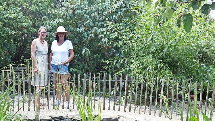 Gartenbesitzerin Birgit Landskron (links) mit einer Besucherin vor dem Gartenteich