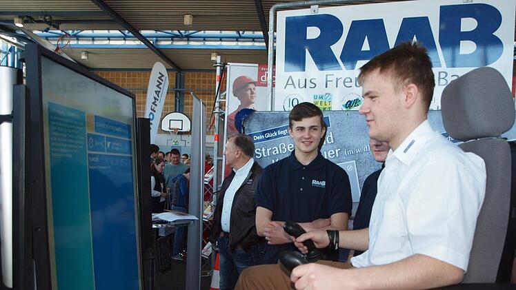 : Der junge Mann kann sich hier am Stand der Firma Raab-Bau als Baggerfahrer fühlen.