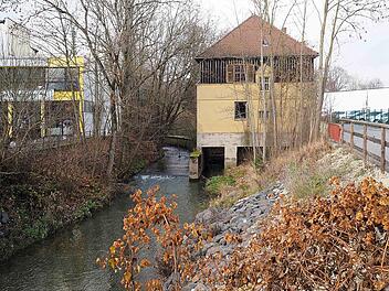 Zwischen der Lauterbrücke in der Raststraße und der Agip-Tankstelle in der Callenberger Straße flussaufwärts entstehen entlang der Lauter die letzten Ufermauern für den Hochwasserschutz. Dazu müssen die wild gewachsenen Bäume am Ufer gefällt werden. Das ehemalige Flusskraftwerk und spätere Pfadfinderheim (im Bild rechts) wird abgebrochen. Foto: Christoph Winter