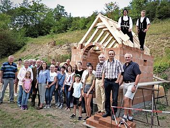 Gemeinsam feierten die Ködnitzer das Richtfest der kleinen Kapelle. Am Dachstuhl von links die beiden Zimmerer David Pöhlmann und Bastian Schmidt, sowie stehend von rechts 2. Bürgermeister Hermann Popp, IG-Sprecher Heinz Mösch und Architekt Wolfram Müller. Foto: Werner Reißaus