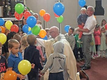 Pfarrer Helmut Hetzel segnete im Gottesdienst die Kinder. Sie waren mit ihrem Ballons zum Gottesdienst gekommen und hatten danach viel Spaß beim Pfarrfest von St. Magdalena. Foto: Manfred Welker