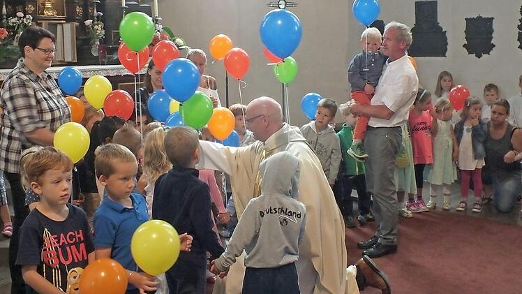 Pfarrer Helmut Hetzel segnete im Gottesdienst die Kinder. Sie waren mit ihrem Ballons zum Gottesdienst gekommen und hatten danach viel Spaß beim Pfarrfest von St. Magdalena. Foto: Manfred Welker