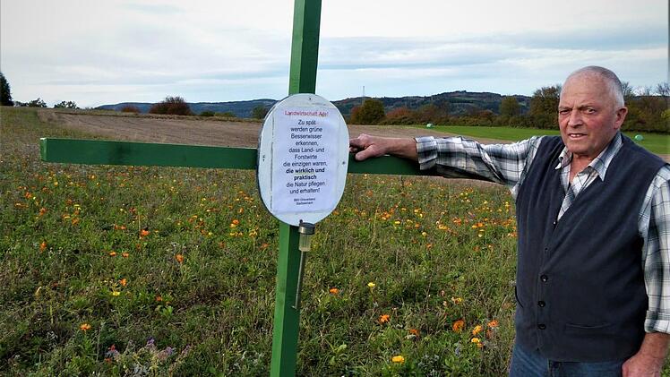 BBV-Obmann Adolf Hildner brachte an einem "Grünen Kreuz" das Schild mit dem Text "Landwirtschaft ade! ..." an. Foto: Werner Reißaus