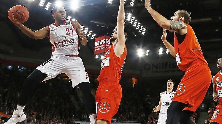 Für Darius Miller (l.) ist der Weg zum Korb versperrt. Die Ulmer Taylor Braun (M.) und Tim Ohlbrecht stellen sich dem Bamberger in den Weg. Fotos: Daniel Löb