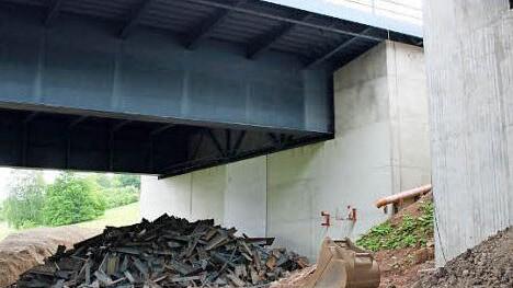 Am geringsten ist der Abstand zwischen alter (links) und neuer Brücke an den Widerlagern. Metallschrott unter der Brücke soll hier die Erschütterungen durch den Aufprall dämpfen. Foto: Ralf Ruppert