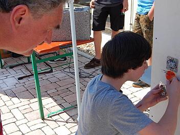 Fabian Diemer stellte den Beruf des Elektronikers vor. Er ist auch nach diesem Praktikum nicht sicher, ob es das Richtige für ihn ist. Schulleiter Hanna schaute dem Schüler interessiert über die Schulter.  Foto: Günther Straub